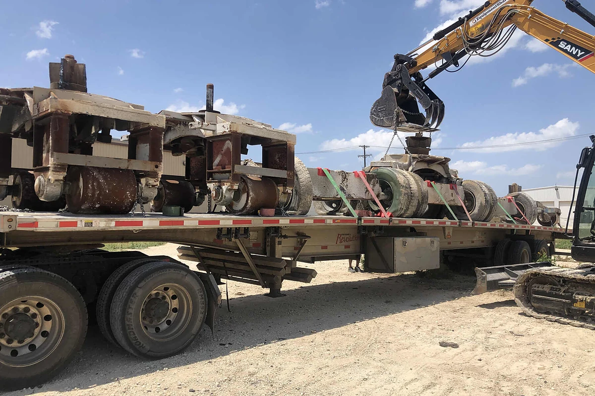 Heavy industrial equipment being removed and loaded for transport
