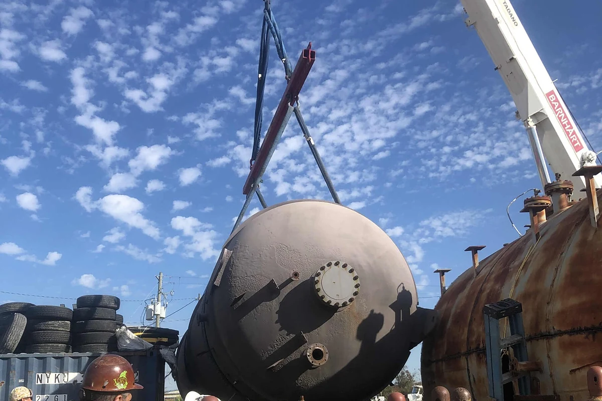 Crane lifting a large vessel during an industrial demolition project